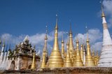 The Shwe Indein Pagoda is a collection of Buddhist stupas dating back to the 17th and 18th centuries CE.<br/><br/>

Inle Lake is a freshwater lake located in the Nyaungshwe Township of Taunggyi District of Shan State, part of Shan Hills in Myanmar (Burma). It is the second largest lake in Myanmar with an estimated surface area of 44.9 square miles (116 km2), and one of the highest at an altitude of 2,900 feet (880 m).<br/><br/>

The people of Inle Lake (called Intha), some 70,000 of them, live in four cities bordering the lake, in numerous small villages along the lake's shores, and on the lake itself. The entire lake area is in Nyaung Shwe township. The population consists predominantly of Intha, with a mix of other Shan, Taungyo, Pa-O (Taungthu), Danu, Kayah, Danaw and Bamar ethnicities. Most are devout Buddhists, and live in simple houses of wood and woven bamboo on stilts; they are largely self-sufficient farmers.<br/><br/>

Most transportation on the lake is traditionally by small boats, or by somewhat larger boats fitted with single cylinder inboard diesel engines. Local fishermen are known for practicing a distinctive rowing style which involves standing at the stern on one leg and wrapping the other leg around the oar. This unique style evolved for the reason that the lake is covered by reeds and floating plants making it difficult to see above them while sitting. Standing provides the rower with a view beyond the reeds. However, the leg rowing style is only practiced by the men. Women row in the customary style, using the oar with their hands, sitting cross legged at the stern.