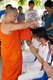Thailand: Thai Buddhist ordination ceremony, Chiang Mai. Firstly the <i>nak</i> or monk-to-be has his head shaved. The first trimmings are made by parents, relatives or a senior monk
