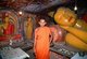 Sri Lanka: A monk in front of Buddha figures at Degaldoruwa Temple, near Kandy