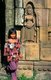 Cambodia: Young Khmer girl in front of an Apsara (Celestial Nymph), Wat Nokor Bayon, Banteay Prey Nokor, Kompong Cham