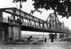 The Long Bien Bridge was erected by the French colonialists between 1899 and 1902 and named the Paul Doumer Bridge in honour of the then Governor of French Indochina (1897–1902).<br/><br/>

It was designed and built by Dayde and Pille of Paris (the original plaques are still in place) and is 1,682 metres (5,518 ft) long, comprising 18 spans, with an additional lengthened central span of 106 metres (347 ft). It carries the only railway line between Hanoi and Haiphong, as well as two vital rail links with China; until the construction of the new Chuong Duong Bridge in 1985, it also carried the only road traffic across the Red River at Hanoi.<br/><br/>

The Long Bien Bridge became a major target – perhaps the major target – of the United States Air Force during the Second Indochina War. At the height of the US bombing offensive it was defended by more than 150 Soviet-supplied SAM missiles, as well as massed batteries of anti-aircraft guns.<br/><br/>

Although hit on numerous occasions, Vietnamese sapper teams working 24 hours a day generally managed to repair the bridge and restore communications within a remarkably short period of time.