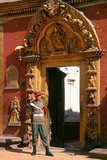 The Golden Gate or Sun Dhoka, marks the entry to the Taleju Temple within the palace complex. The gate was built in 1753 by Ranajita Malla (r. 1722 - 1769) and his wife Jayalakshmi to commemorate the performance of a religious fire rite (<i>kotyahuti-yagya</i>), and it turned out to be the finest piece of gilded copper-work in Bhaktapur, possibly in the whole Kathmandu Valley.<br/><br/>

Highly ornate in itself, the panels left and right of the door, depicting ten different deities, are superb examples of the art of repoussé. On the panels, Ranajita is mentioned as the ruler of a territory that extended as far as the Dudhkoshi River in the east, including the town of Dolakha.<br/><br/>

Above the door, the golden <i>torana</i> shows Taleju Bhavani with her sixteen arms radiating out like some strange kind of half-insect, half-goddess. Above her, at the top of the <i>torana</i>, an image shows the Garuda with serpents coiling all around him.
