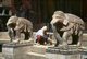Nepal: A sweeper cleans next to the elephants guarding the southern entrance to the Changu Narayan Temple, Kathmandu Valley