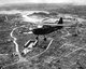 Japan / USA: A U.S. Marine Corps Stinson Sentinel flies over the razed city of Naha, capital of Okinawa. Battle of Okinawa, May 1945