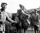 China / Burma / Myanmar: Chinese Nationalist soldiers of the Chinese Expeditionary Force transporting weapons and a pet monkey to the front. Linxiang District, Yunnan Province, 10 July 1944