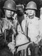 China / Japan: Imperial Japanese soldiers display a bullet-pocked helmet that saved the life of their comrade (centre) during the Battle of Beijing, Second Sino-Japanese War, July 1937