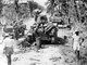 Philippines / USA: US soldiers and Filipino Resistance fighters examine two destroyed Japanese Ha-Go light tanks with their dead crewmen, Binalonan, Pangasinan, Luzon, 29 Jauary 1945