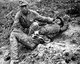 Burma / Myanmar / China: A Chinese soldier tends to a wounded comrade waiting to be transported to a medical dressing station behind the front lines during the Burma Campaign, Hukawng Valley, Kachin State, April 1944