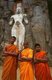 Sri Lanka: Young Buddhist monks in front of 1000 year old carved stone figures representing the Avalokitesvara (centre) and his consort Tara (right), and their son Prince Sudana, Buduruvagala