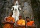 Sri Lanka: Young Buddhist monks in front of 1000 year old carved stone figures representing the Avalokitesvara (centre) and his consort Tara (right), and their son Prince Sudana, Buduruvagala