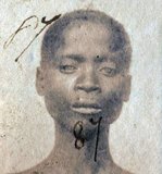 This photograph of a 'Liberated African' slave was taken after they were freed from slaving ships by the British Navy. From 1861 to 1874, more than 2500 'Liberated Africans' were shipped to Port Victoria, Seychelles.<br/><br/>

While the Slave Trade continued across eastern and southern Africa and the Indian Ocean, the 'liberated' were taken to a depot, classified by the District Magistrate, photographed, renamed, and assigned as 'apprentices' to the French-owned plantations, where they were indentured for five years.