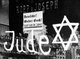 Germany: A Jewish-owned shop vandalized by Nazis with poster reading 'Germans Defend Yourselves - Don't Buy from Jews', 1938