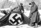 Russia / Germany: Warmly-clad Soviet soldiers inspect a captured Nazi flag, Stalingrad, February 1943