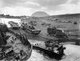 Japan / USA: Destroyed American amtracs (amphibious landing crafts) and other vehicles on a beach at Iwo Jima, Mount Suribachi in distance, March 1945