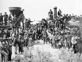 The First Transcontinental Railroad (known originally as the 'Pacific Railroad' and later as the 'Overland Route') was a 1,907-mile (3,069 km) contiguous railroad line constructed in the United States between 1863 and 1869 west of the Mississippi and Missouri Rivers to connect the Pacific coast at San Francisco Bay with the existing eastern U.S. rail network at Council Bluffs, Iowa.<br/><br/>

Opened for through traffic on May 10, 1869 with the ceremonial driving of the 'Last Spike' at Promontory Summit, the road established a mechanized transcontinental transportation network that revolutionized the settlement and economy of the American West by bringing these western states and territories firmly and profitably into the Union and making goods and transportation much quicker, cheaper, and more flexible from coast to coast.