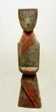 This grave figurine is abstract and modernistic in appearance. Traces of red paint, representing textile patterns, remain on the figure's carved robe.<br/><br/>

Typically of costume in this period, the face is the only visible part of the attendant's body; even her hands are concealed and clasped beneath long sleeves, in the formal posture of waiting for orders.