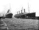 UK: RMS Titanic (right) moving out of the drydock to allow her sister liner, RMS Olympic, to replace a damaged propeller blade, Belfast, 6 March 1912