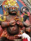 The Kala Bhairav or Black Bhairav is a 3m-high statue depicting a sword-wielding, terror-inducing manifestation of Shiva trampling on some unfortunate victim. Local lore has it that the image was found on the Nagarjun mountain on the western rim of the Kathmandu Valley and brought to its current place by King Pratapa Malla.<br/><br/>

Once the image was set up in Durbar Square, royal courtiers had to swear oaths of allegiance in front of it and witnesses in criminal cases had to testify in its presence. It was believed that anybody telling lies in front of Kala Bhairav would immediately die. Kala Bhairav also demanded blood sacrifices and until today numerous animals are slaughtered in front of the figure during the festival of Dassain.<br/><br/>

Bhairava sometimes known as Kala Bhairava, is a Hindu deity, a fierce manifestation of Shiva associated with annihilation. He originated in Hindu mythology and is sacred to Hindus, Buddhists and Jains alike. He is worshipped in Nepal, Rajasthan, Karnataka, Tamil Nadu and Uttarakhand.