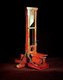 A guillotine is an apparatus designed for efficiently carrying out executions by beheading. The device consists of a tall, upright frame in which a weighted and angled blade is raised to the top and suspended. The condemned person is secured with stocks at the bottom of the frame, positioning the neck directly below the blade. The blade is then released, to fall swiftly and forcefully decapitating the victim with a single pass so that the head falls into a basket below.<br/><br/> 

The device is best known for its use in France, in particular during the French Revolution, where it was celebrated as the people's avenger by supporters of the revolution and vilified as the pre-eminent symbol of the Reign of Terror by opponents. The name dates from this period, but similar devices had been used elsewhere in Europe over several centuries.