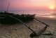 India: A traditional Goan outrigger fishing boat sits on the beach at Calangute Beach, North Goa