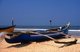 India: A traditional Goan outrigger fishing boat sits on the beach at Benaulim Beach, South Goa