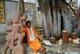 India: A pilgrim sits next to a statue of Hanuman, the Monkey god, near the Hindu Omkareshwar Mahadev Temple on the Narmada River, Madhya Pradesh