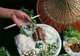 Vietnam: <i>Nem nuong</i> or grilled Vietnamese pork sausage, served with noodles, rice paper, fresh vegetables, herbs and garlic, accompanied by a peanut sauce and fermented pork