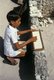 Maldives: A boy uses a sand tray and stick pen to practise his writing skills. In the past a traditional way to learn to write. Addu Atoll (Seenu Atoll) 1980
