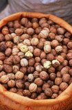A walnut is an edible seed of any tree of the genus <i>Juglans</i> (Family Juglandaceae), especially the Persian or English walnut, <i>Juglans regia</i>. Broken nutmeats of the eastern black walnut from the tree <i>Juglans nigra</i> are also commercially available in small quantities, as are foods prepared with butternut nutmeats from <i>Juglans cinerea</i>.<br/><br/>

Walnuts are rounded, single-seeded stone fruits of the walnut tree. The walnut fruit is enclosed in a green, leathery, fleshy husk. This husk is inedible. After harvest, the removal of the husk reveals the wrinkly walnut shell, which is in two halves. This shell is hard and encloses the kernel, which is also made up of two halves separated by a partition. The seed kernels — commonly available as shelled walnuts — are enclosed in a brown seed coat which contains antioxidants.