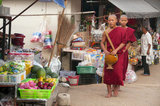 Thailand: Buddhist monks on their early morning almsround through the market at Doi Mae Salong (Santikhiri), Chiang Rai Province. Doi Mae Salong was once an impoverished, heavily-armed Kuomintang (KMT) outpost, it is today a tranquil oasis of tea gardens, fruit orchards and Yunnanese-style houses.
