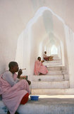 Burma / Myanmar: Buddhist nuns on a staircase at the Hsinbyume Pagoda, close to the Mingun Pahtodawgyi (Mingun Temple), Sagaing District, near Mandalay. The Hsinbyume Pagoda was built in 1816 by King Bagyidaw (1784 - 1846), the seventh king of the Konbaung Dynasty. He built it for his first wife, Princess Hsinbyume who died in childbirth in 1812. The pagoda is also known as the Myatheindan Pagoda. The pagoda's design is based on the mythical Sulamani Pagoda found on Mount Meru, with the seven lower concentric terraces representing the mountain ranges leading to Mount Meru.