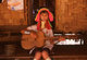 Thailand: Padaung (Long Neck Karen) woman plays a locally produced guitar in a village near Mae Hong Son, northern Thailand
